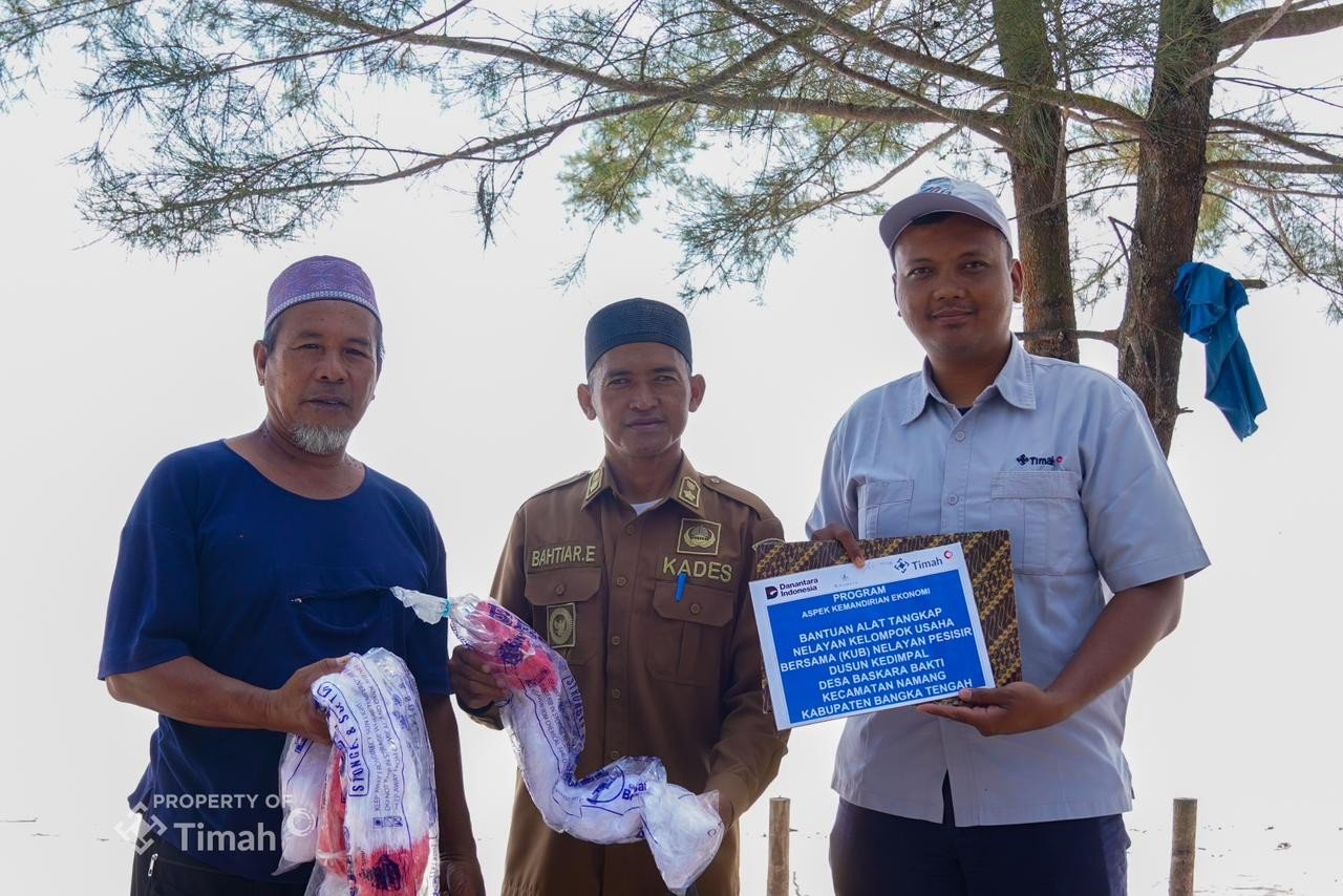 Karyawan PT Timah Tbk (kanan) didampingi Kepala Desa Baskara Bakti Bahtiar Efendi (tengah) saat menyalurkan bantuan alat tangkap nelayan kepada Ketua KUB Nelayan Pesisir Dusun Dusun Kedimpel, M. Riduan. Foto/PT Timah